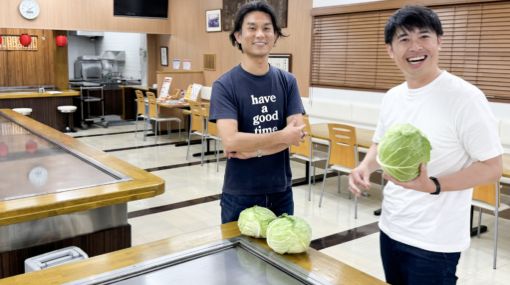 お好み焼の鉄板の前で笑顔で映る卒業生２名